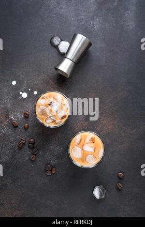 White Russian Cocktails mit Wodka, Kaffeelikör und Creme. Hausgemachte Eistee Alkohol versoffenen White Russian oder Lebowski Drink mit Kaffeebohnen auf rustikalen b Stockfoto