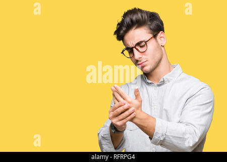 Jungen gutaussehenden Mann Brille über isolierte Hintergrund Schmerzen an den Händen und Fingern, Arthritis Entzündung Stockfoto