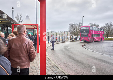 Eine Warteschlange von Menschen warten auf dem Bürgersteig an Bord eines Doppeldeckerbusses am Madingley Park und Ride Busbahnhof, Cambridge, England. Stockfoto