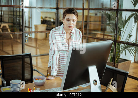 Dunkelhaarige Innenarchitekt lesen Business Brief von Ihrem Client Stockfoto