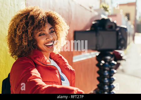Nahaufnahme von einem lächelnden afro-amerikanische Frau, Tourist, der eine selfie mit Ihrer Digitalkamera. Weibliche touristische blogger Aufnahme Inhalt für Ihre Reise blo Stockfoto