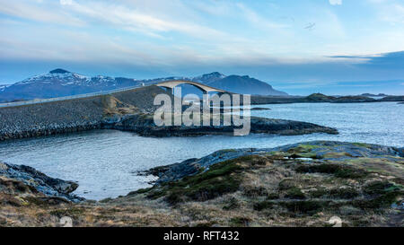 Ansicht des Storseisundet Brücke mit Bergen im Hintergrund von Eldhusøya auf der Atlantikstraße in Norwegen Stockfoto