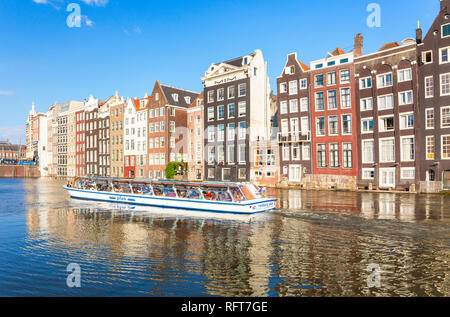 Reihe der typischen holländischen Häusern, in der Damrak Kanal mit Kanal tour Boot, Amsterdam, Nordholland, Niederlande, Europa Stockfoto