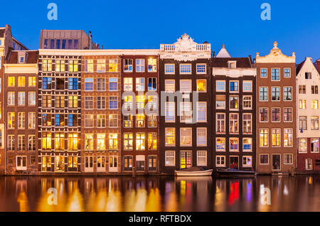 Niederländische Giebel an Reihe der typischen Amsterdamer Häuser in der Nacht mit Reflexionen in der Damrak, Kanal, Amsterdam, Nordholland, Niederlande, Europa Stockfoto