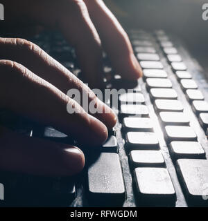 Aus der Nähe. Ein Mann der Texteingabe auf einem Laptop Tastatur. Stockfoto