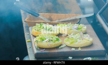 Vorbereitung der Burger bei Street Food Festival. Kochen im Freien, Gastronomie und Street Food Konzept Stockfoto