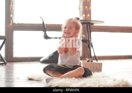 Gerne kleine Mädchen sitzen auf dem Teppich im Wohnzimmer. Stockfoto