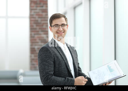 Lächelnd Geschäftsfrau mit Zwischenablage stehen im Büro. Stockfoto