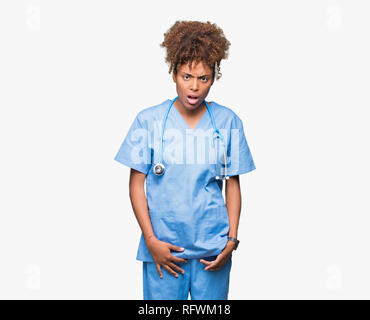 Junge afrikanische amerikanische Ärztin Frau über isolierte Hintergrund im Schock Gesicht, schaut skeptisch und sarkastisch, mit offenem Mund überrascht Stockfoto