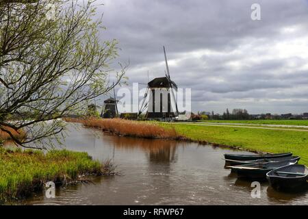 Ruderboote sind auf der Mühle Teich, oder Polder festgemacht, neben dem berühmten Windmühlen von Stompwijkse Vaart, in der Nähe von Den Haag, Holland. Stockfoto