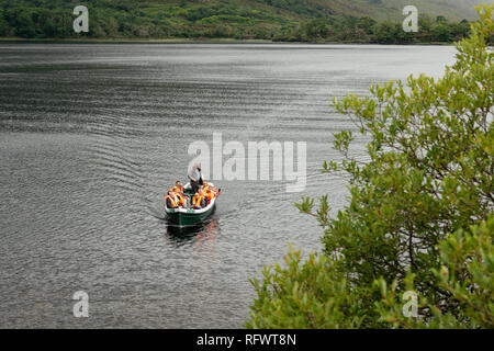 Seen von Killarney Bootsfahrt und Touristen im Rudermotorboot auf dem Berg Muckross See im Killarney National Park, County Kerry, Irland. Stockfoto