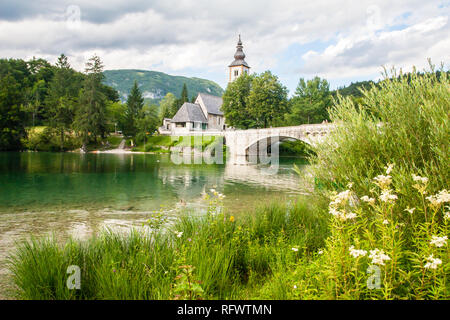 Die Brücke und Kirche im Dorf am Seeufer von Ribcev Laz, Bohinjer See, Slowenien, Europa Stockfoto