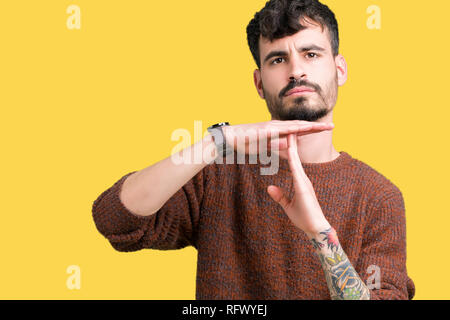 Jungen gutaussehenden Mann tragen winter Pullover über isolierte Hintergrund tun time out Geste mit den Händen, frustriert und ernstes Gesicht Stockfoto