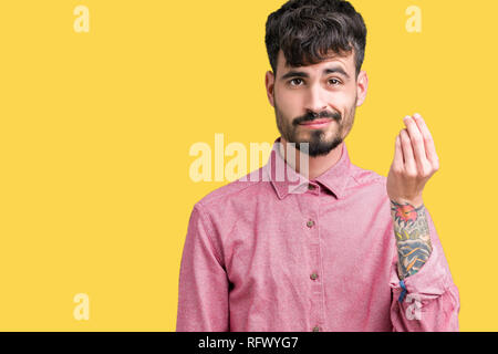 Jungen gutaussehenden Mann mit rosa Shirt über isolierte Hintergrund tun Italienische Geste mit der Hand und den Fingern zuversichtlich Ausdruck Stockfoto