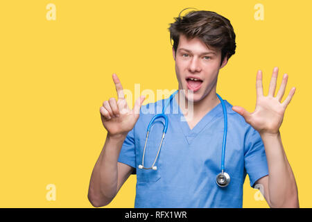 Junger Arzt mit medizinischen gleichmäßig über isolierte Hintergrund angezeigt und zeigen mit den Fingern Nummer sieben, während lächelte zuversichtlich und fröhlich. Stockfoto
