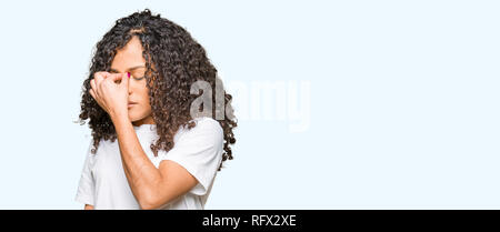 Junge schöne Frau mit lockigem Haar tragen weiße t-shirt Müde rieb Nase und Augen Gefühl der Müdigkeit und Kopfschmerzen. Stress und Frustration Konzept. Stockfoto