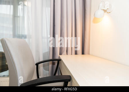 Leere Tabelle in Minimalismus Haus innen und weiße Wand Schlafzimmer Büro mit Schreibtisch, Stuhl und niemand von Leuchte und Balkon Fenster Stockfoto