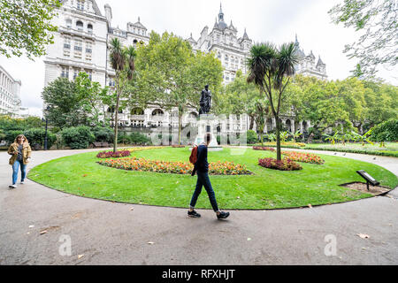 London, Großbritannien - 12 September 2018: Leute, Touristen zu Fuß in Whitehall Gardens mit grünem Gras von Thames River Victoria Embankment in Westminster Stockfoto