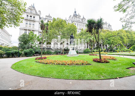 London, Großbritannien - 12 September 2018: Whitehall Gardens mit grünem Gras und William Tyndale Statue von Thames River Victoria Embankment in Westminster und Stockfoto