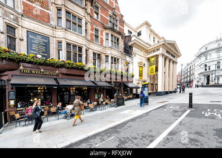 London, Großbritannien - 12 September, 2018: die Menschen zu Fuß pendeln auf der Straße auf der Straße mit der Wellington Pub Restaurant unterzeichnen und Bürgersteig in den Strang in Cove Stockfoto