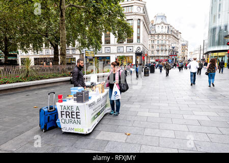 London, Großbritannien - 12 September 2018: Menschen, Frau und Mann durch Freie Quaran Islam Religion stand stand auf dem Bürgersteig Street Shopping in Leicester Square Stockfoto