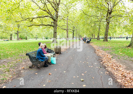 London, Großbritannien - 12 September 2018: Alley Pfad im Green Park in Westminster Landschaft Aussicht bei Tag im Vereinigten Königreich mit romantischen Paar auf Sitzung b Stockfoto