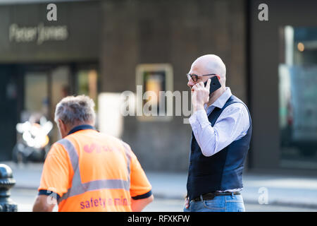 London, Großbritannien - 13 September, 2018: Geschäftsmann am Telefon sprechen von Arbeitnehmern in Chelsea mit Hintergrund der Straße Straße Stockfoto