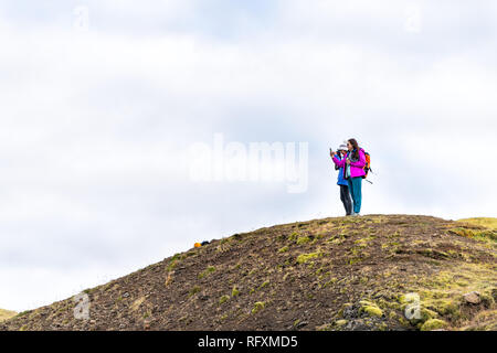 Hveragerdi, Island - 18. September 2018: Trail im Reykjadalur während des Tages im Süden golden circle Landschaft und zwei Menschen standen an der Spitze des Berges Stockfoto