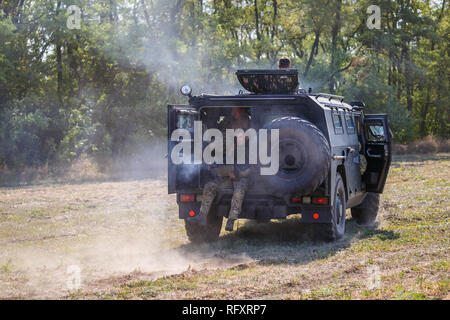 Historische Festival Sambek Höhen. Soldaten der Special purpose Ablösung fahren in einem gepanzerten Auto auf dem Feld und schoß ein Maschinengewehr Stockfoto