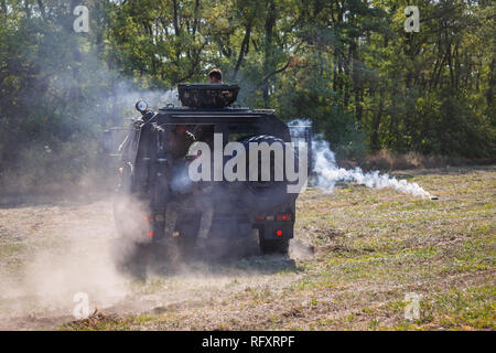 Historische Festival Sambek Höhen. Soldaten der Special purpose Ablösung fahren in einem gepanzerten Auto auf dem Feld und schoß ein Maschinengewehr Stockfoto