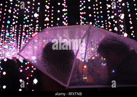 Klar Schirm im Regen und Lichter in London Canary Wharf Winter Lights Festival 2019 Stockfoto