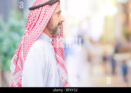 Senior arabischen Mann mit kufiya über isolierte Hintergrund auf der Suche nach Side, entspannen Profil mit natürliches Gesicht mit selbstbewussten Lächeln darstellen. Stockfoto