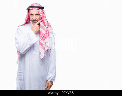 Senior arabischen Mann mit kufiya über isolierte Hintergrund in die Kamera schaut zuversichtlich mit Smile mit verschränkten Armen und Hand am Kinn angehoben. Thinki Stockfoto