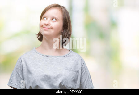 Junge erwachsene Frau mit Down-syndrom über isolierte Hintergrund lächelnd Seite suchen und sie starrte Denken. Stockfoto