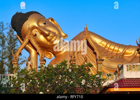 Der liegende Buddha (Buddha im Augenblick des Todes), Wat Si Sunthorn, Phuket, Thailand, kurz nach Sonnenaufgang mit dem Vollmond am Himmel über seinem Kopf Stockfoto