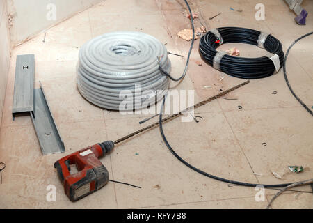 Elektrische Kabel, Leitungen, Isolierung, Spezial-locher mit langen Bohrer, perforator, Profil aus Aluminium, Bauschutt auf schmutzige Fliesen bei Co Stockfoto