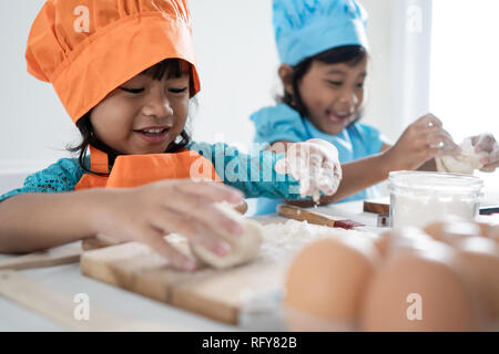 Zwei Mädchen Kleinkinder lernen Kochen und einige Teig zu machen Stockfoto