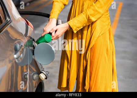 Frau Hinzufügen von Benzin an der Tankstelle allein Stockfoto