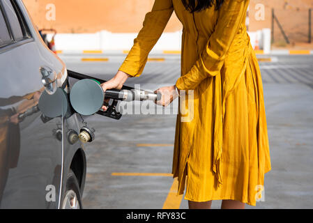 Frau Hinzufügen von Benzin an der Tankstelle allein Stockfoto