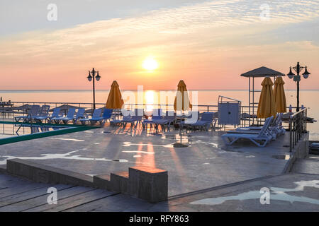 Sonnenstrahlen fallen auf konkrete Liegewiese auf Marine dawn Hintergrund. Stockfoto