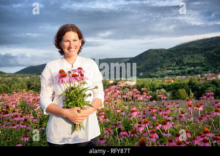 Echter Bauer Frau in coneflower Feld Stockfoto