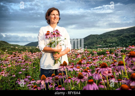 Echter Bauer Frau in coneflower Feld Stockfoto