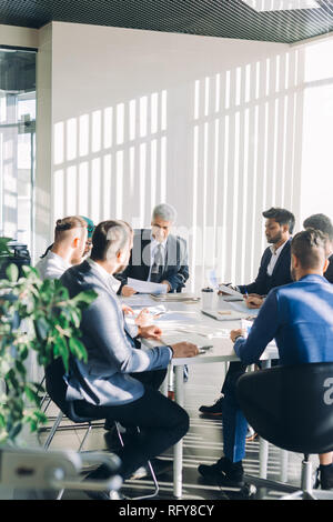 Multirassischen männliche Führungskräfte Projekt am Konferenztisch sitzen besprechen Stockfoto