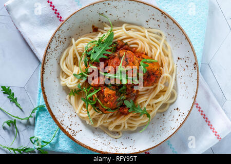 Spaghetti mit Thunfisch Kugeln in pikanter Tomatensauce und Rakete Stockfoto