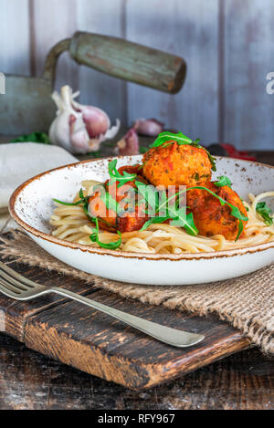 Spaghetti mit Thunfisch Kugeln in pikanter Tomatensauce und Rakete Stockfoto
