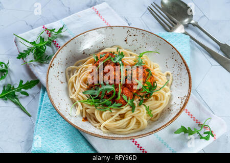Spaghetti mit Thunfisch Kugeln in pikanter Tomatensauce und Rakete Stockfoto