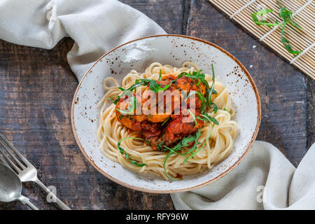 Spaghetti mit Thunfisch Kugeln in pikanter Tomatensauce und Rakete Stockfoto