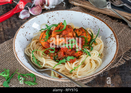 Spaghetti mit Thunfisch Kugeln in pikanter Tomatensauce und Rakete Stockfoto