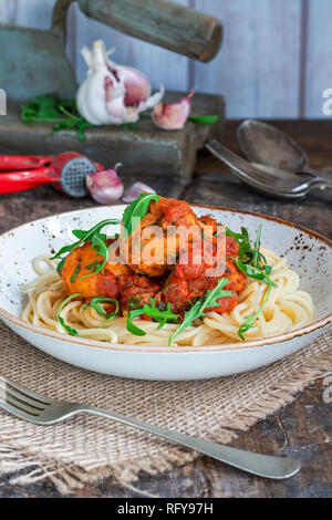 Spaghetti mit Thunfisch Kugeln in pikanter Tomatensauce und Rakete Stockfoto
