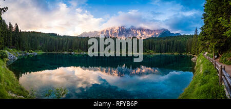 Panoramablick auf die Berge Latemar, Spiegelung in der Karersee, Lago di Carezza bei Sonnenaufgang Stockfoto